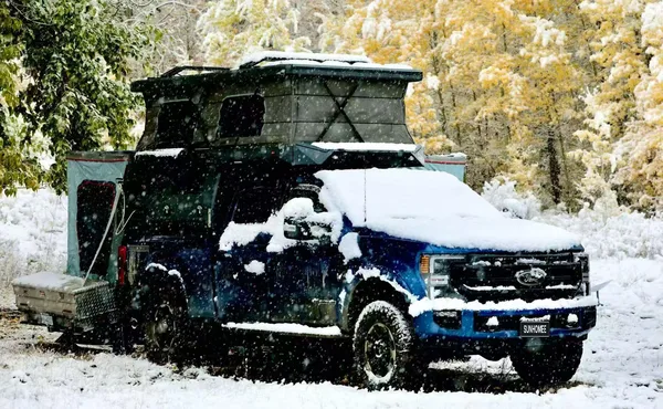 Ford Super Duty with a slide-on camper in fresh snow