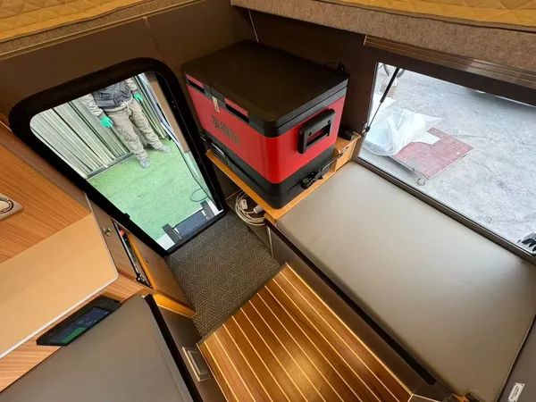 Warm-lit slide-on camper interior with wood table