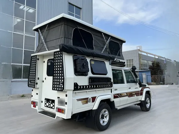 White Toyota Land Cruiser 79 with a SUNHOMEE tray-mount camper, rear three-quarter view