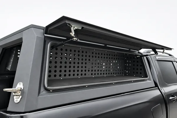 Ute canopy side door open showing the perforated tool-box panel