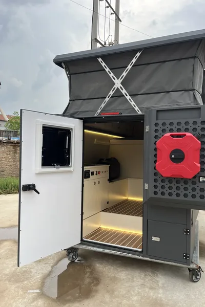 Rear of a SUNHOMEE tray-mount camper with the door open and roof raised